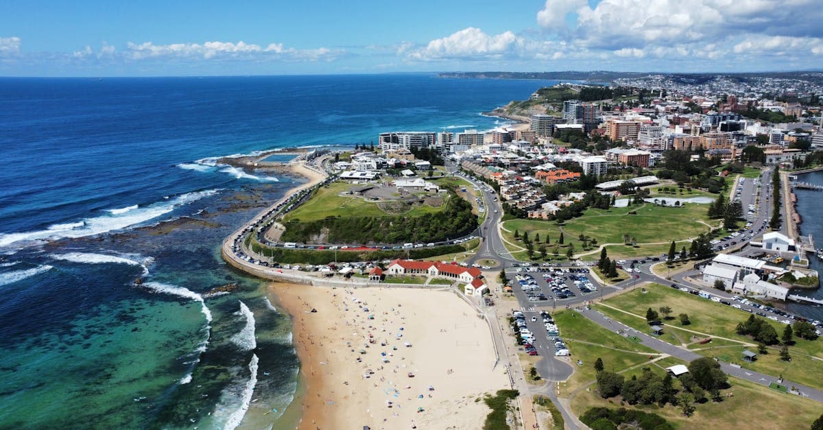 Stunning aerial shot of Newcastle beach, coast, and cityscape on a sunny day.